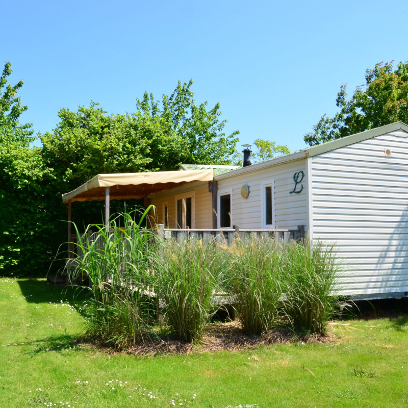 Mobil-home entouré de verdure dans un camping calme en Vendée